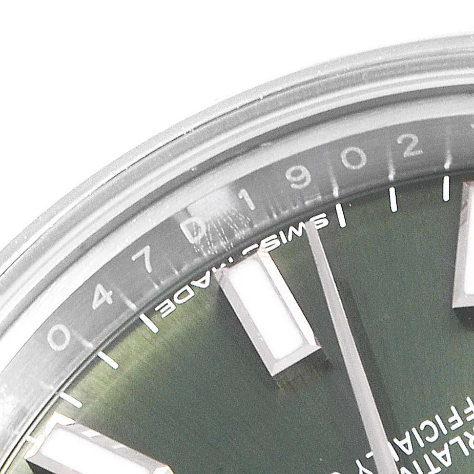 This close-up image of a Rolex Oyster Perpetual 176200 Women's Stainless Steel Green Dial 176200 Women's Stainless Steel Green Dial watch shows the upper left dial, including hour markers and minute numerals.