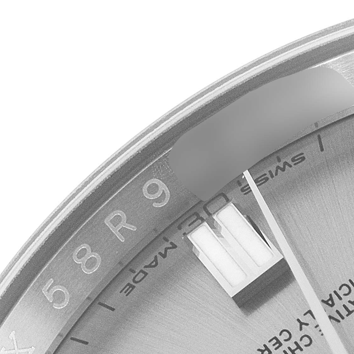 The image shows a close-up of the outer edge of the dial and minute hand of a Rolex Oyster Perpetual 116000 Men's Stainless Steel Grey Dial 116000 Men's Stainless Steel Grey Dial watch.