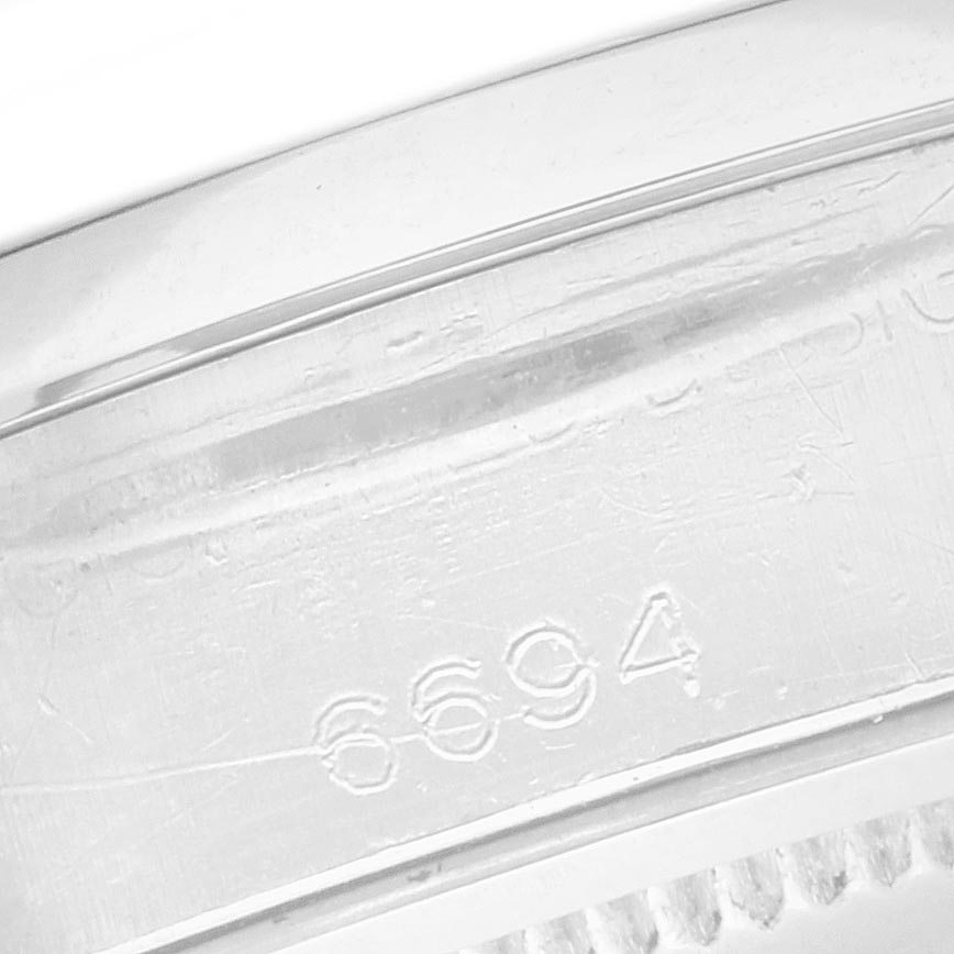 The image shows a close-up of the engraved serial number on the Rolex Vintage Collection 6694 Men's Stainless Steel Black Dial 6694 Men's Stainless Steel Black Dial watch case.