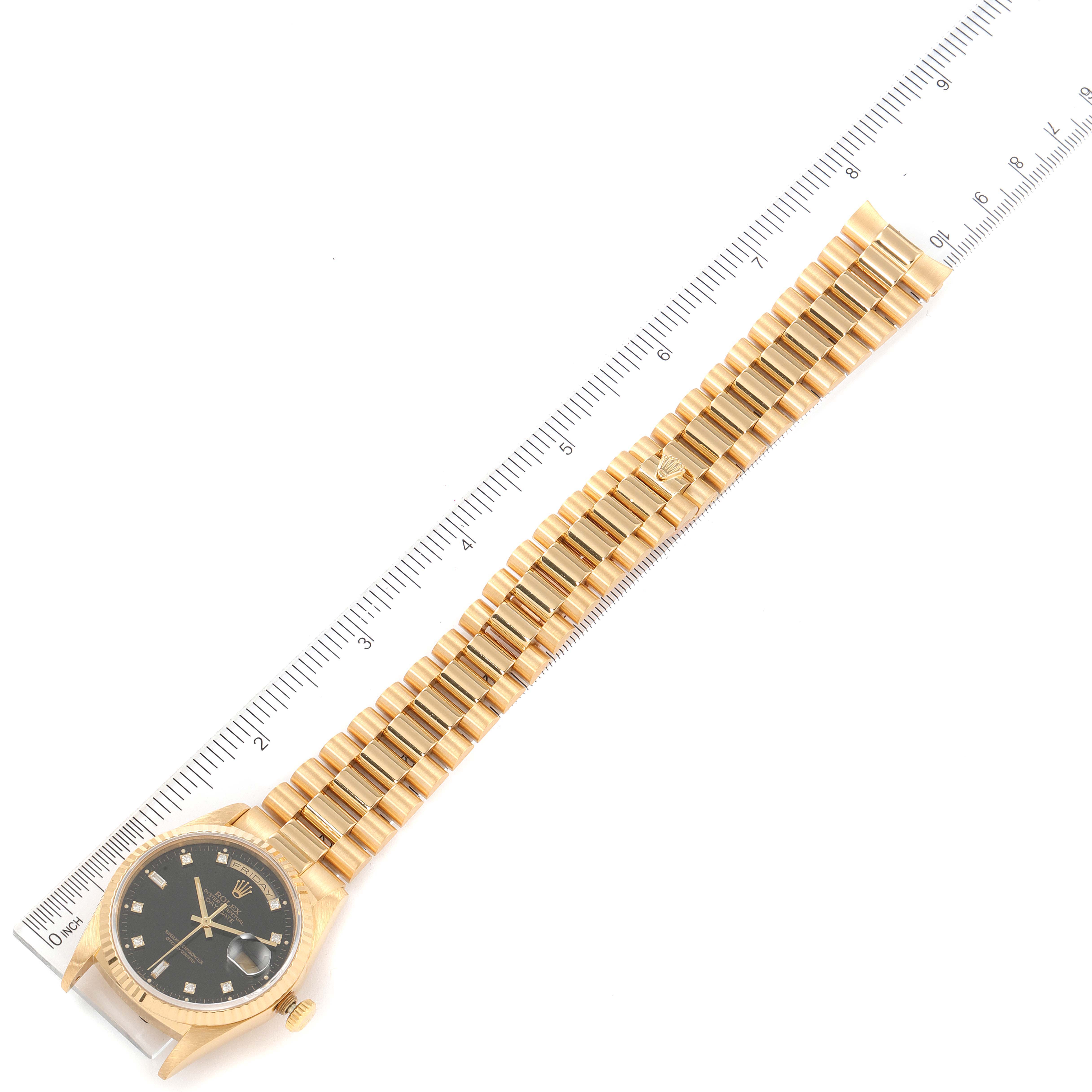 The image displays a Rolex President 18238 Men's Yellow Gold Black Dial 18238 Men's Yellow Gold Black Dial model watch, showing its face and gold link bracelet from an overhead angle alongside a ruler.