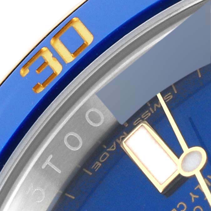 This close-up image of the Rolex Submariner 116613LB Men's Steel and Gold (two tone) Blue Dial 116613LB Men's Steel and Gold (two tone) Blue Dial shows part of the bezel, dial, and hands.