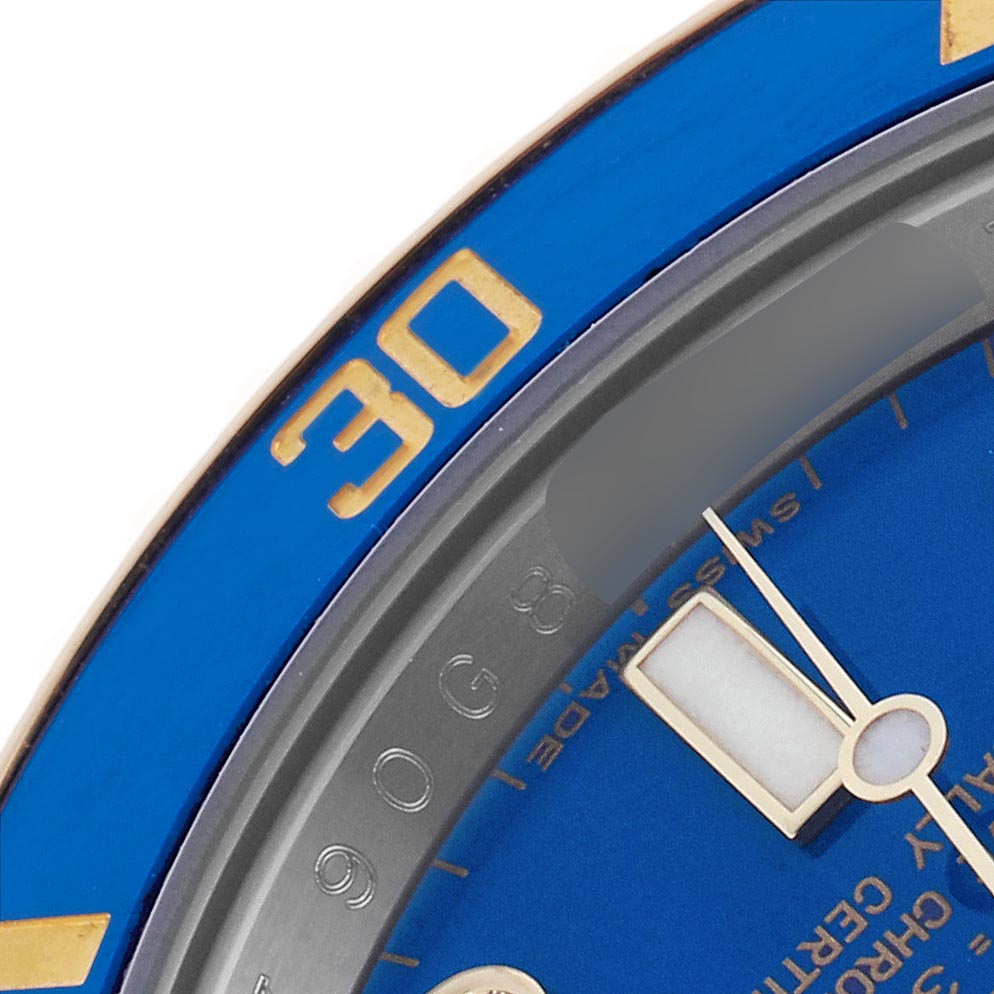 The image shows a close-up of the Rolex Submariner 116613LB Men's Steel and Gold (two tone) Blue Dial 116613LB Men's Steel and Gold (two tone) Blue Dial's blue bezel and part of the dial with a minute hand.