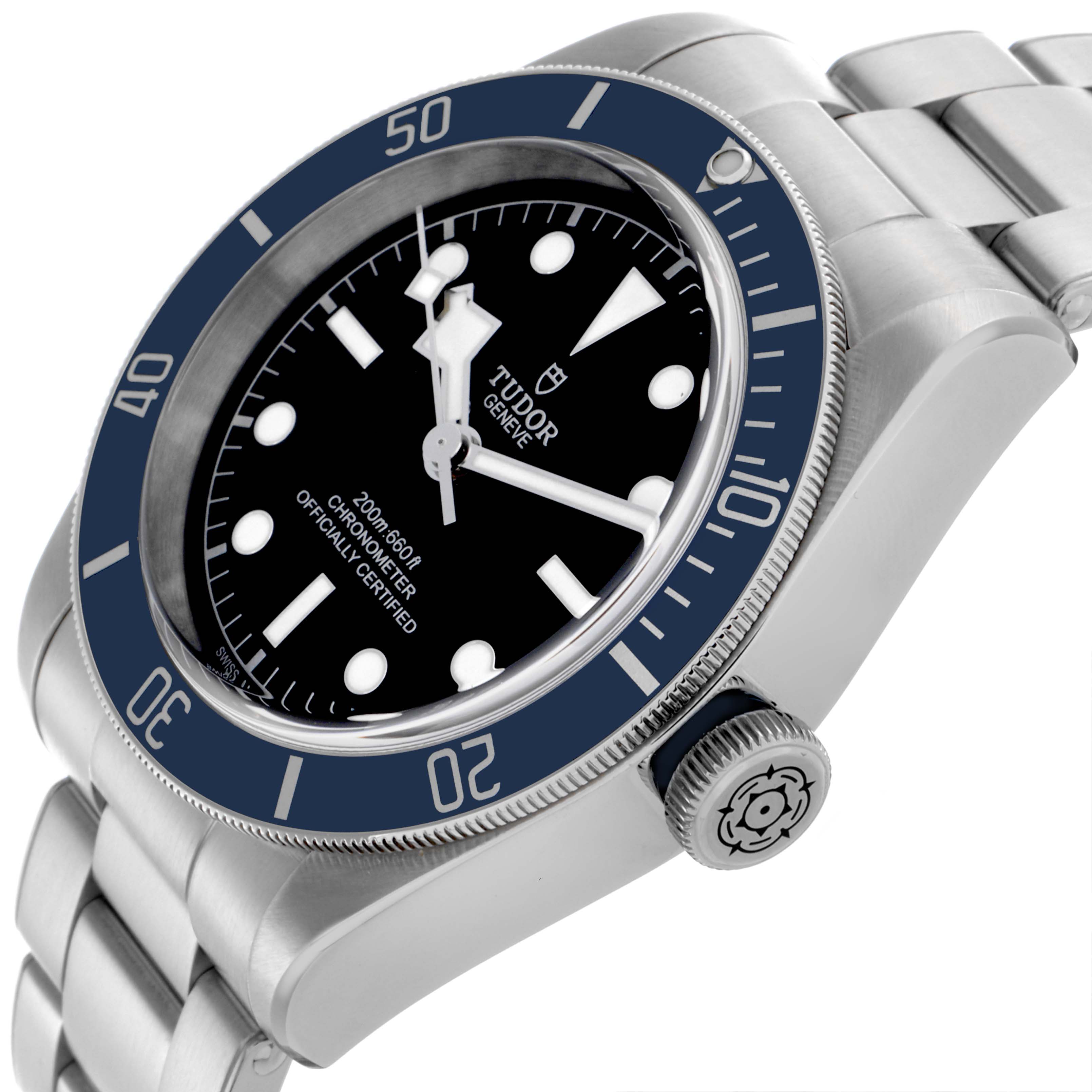 The Tudor Heritage Black Bay 79230B Men's Stainless Steel Black Dial 79230B Men's Stainless Steel Black Dial watch is shown at a tilted angle, highlighting the bezel, crown, dial, and part of the bracelet.