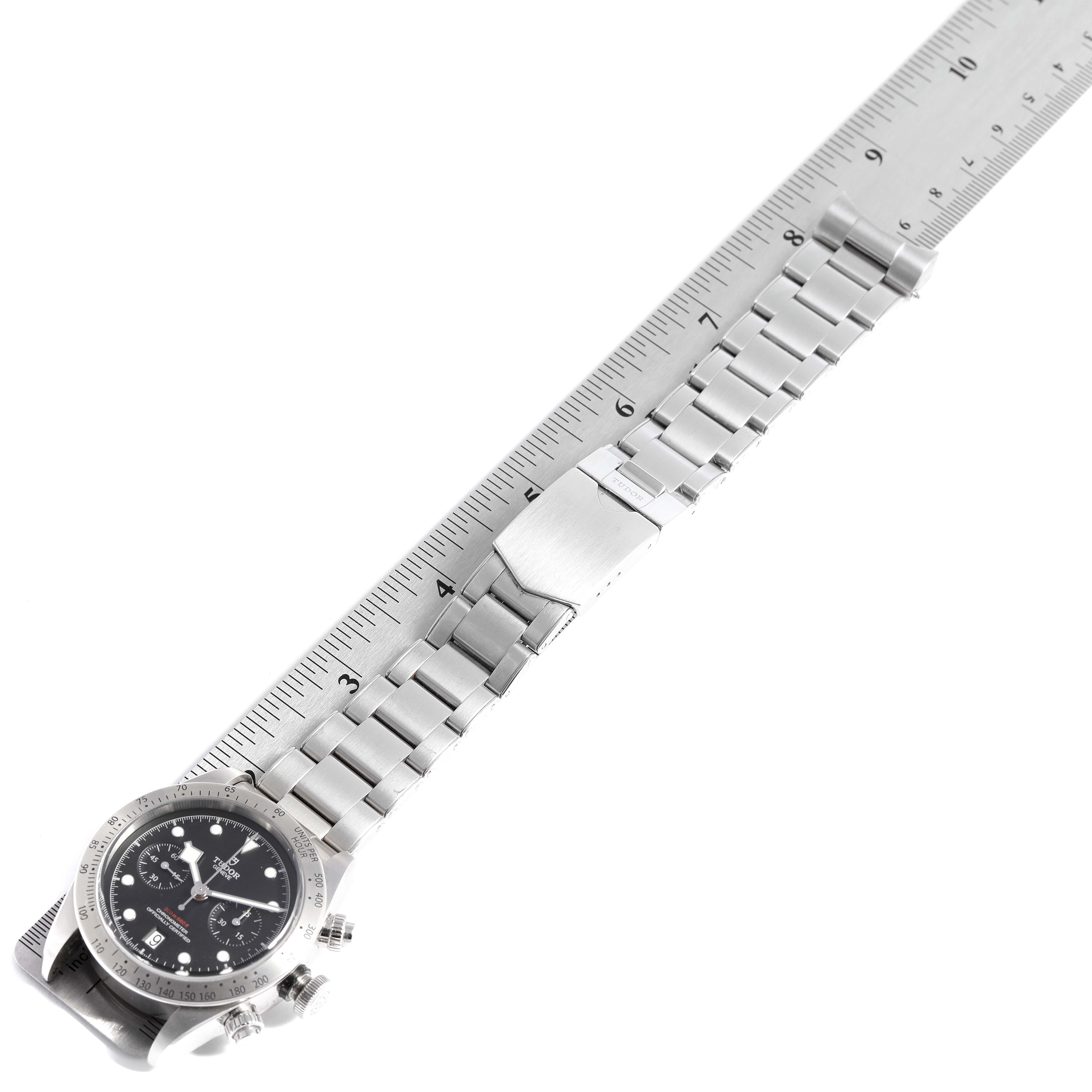 The image shows a side view of a Tudor Heritage Black Bay 79350 Men's Stainless Steel Black Dial 79350 Men's Stainless Steel Black Dial watch with its metal bracelet placed next to a ruler.