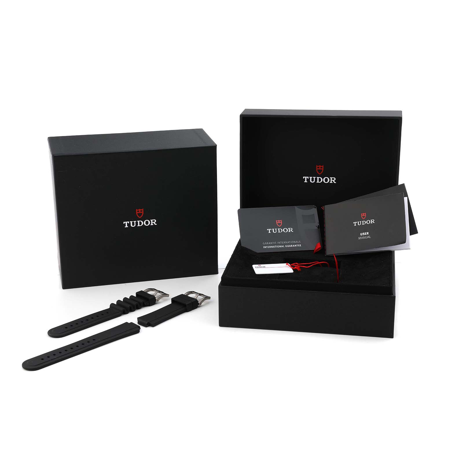 The Tudor Pelagos M25610TNL Men's Titanium Black Dial set includes an open box with manuals and straps laid out beside it, viewed from a front angle.