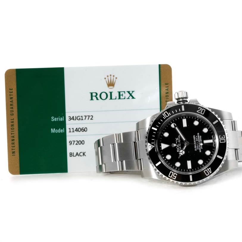 The image shows a Rolex Submariner 114060 Men
s Stainless Steel Black Dial 114060 Men
s Stainless Steel Black Dial watch, model 114060, displayed with its international guarantee card.