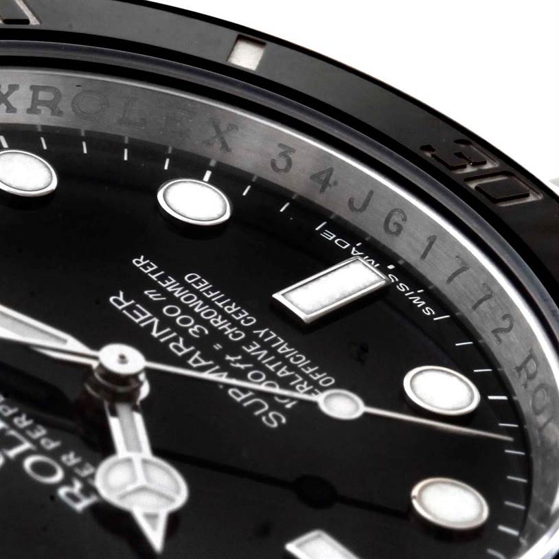The close-up image of the Rolex Submariner 114060 Men
s Stainless Steel Black Dial 114060 Men
s Stainless Steel Black Dial watch shows its dial, hands, markers, and part of the bezel at an angle.