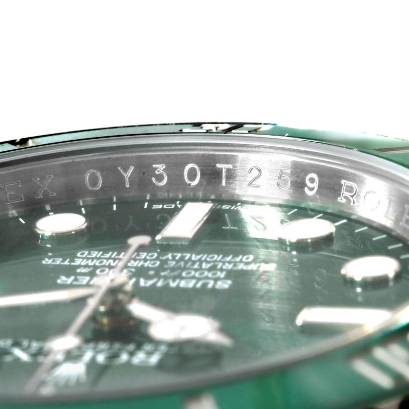 The image shows a close-up angle of the Rolex Submariner 116610LV Men's Stainless Steel Green Dial 116610LV Men's Stainless Steel Green Dial watch, focusing on the inner bezel with engraved serial number and part of the dial.