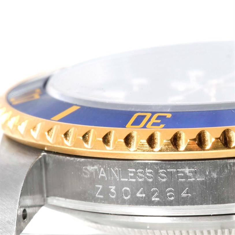 The image shows a close-up side view of the bezel and part of the case of a Rolex Submariner 16613 Men
s Steel and Gold (two tone) Blue Dial 16613 Men
s Steel and Gold (two tone) Blue Dial watch, with the model number visible.