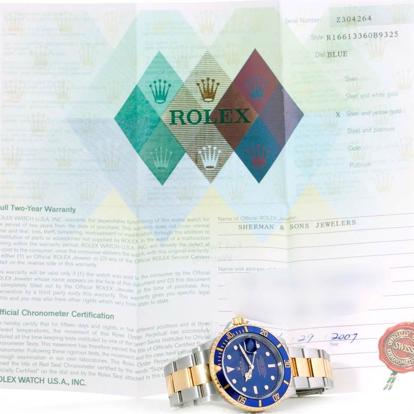 The image shows a Rolex Submariner 16613 Men
s Steel and Gold (two tone) Blue Dial 16613 Men
s Steel and Gold (two tone) Blue Dial watch in steel and gold, angled from the front, with its warranty certificate in the background.