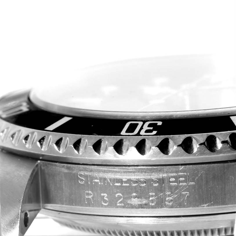The image shows a close-up side angle of the bezel and case of a Rolex Submariner 168000 Men
s Stainless Steel Black Dial 168000 Men
s Stainless Steel Black Dial, highlighting the stainless steel and serial number.