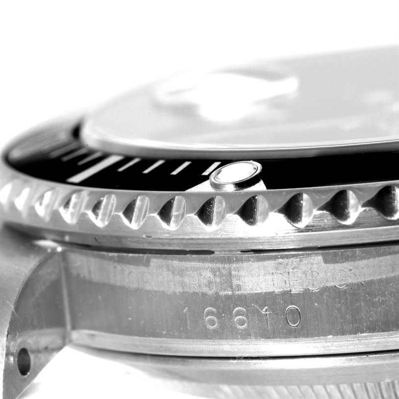 This close-up angle shows the bezel, part of the dial, and the case with "Submariner 16610" model number engraved on the Rolex watch.