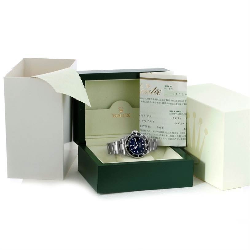 The Rolex Submariner 16610 Men
s Stainless Steel Black Dial 16610 Men
s Stainless Steel Black Dial watch is displayed inside its opened green box, with the original packaging and papers also visible.