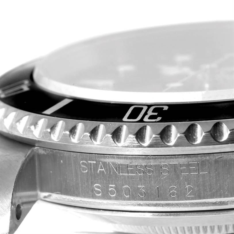 The image shows a close-up side view of the bezel and case of a Rolex Submariner 16610 Men
s Stainless Steel Black Dial 16610 Men
s Stainless Steel Black Dial watch with serial numbers engraved.