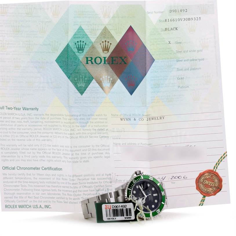 The image shows a side view of the Rolex Submariner 16610LV Men
s Stainless Steel Black Dial 16610LV Men
s Stainless Steel Black Dial watch with warranty paperwork in the background.