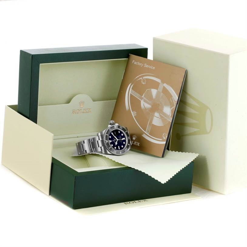The image shows a Rolex Submariner 116610 Men
s Stainless Steel Black Dial 116610 Men
s Stainless Steel Black Dial watch laid atop its box with a manual and cleaning cloth.