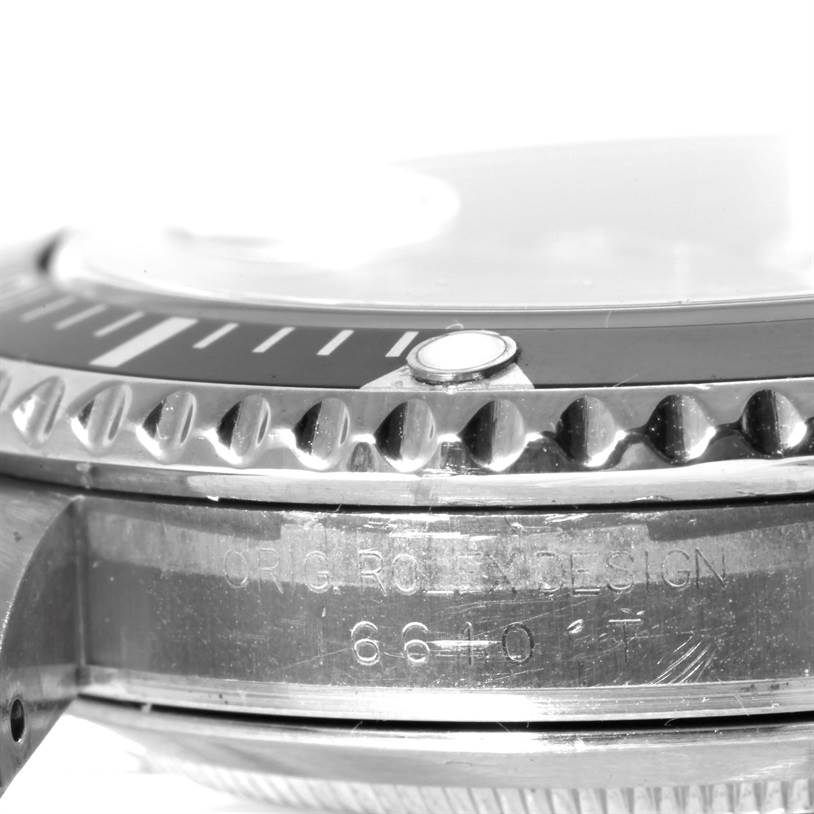 This image shows a close-up of the bezel, crystal, and case side of a Rolex Submariner 16610 Men
s Stainless Steel Black Dial 16610 Men
s Stainless Steel Black Dial watch, revealing part of its engraving.
