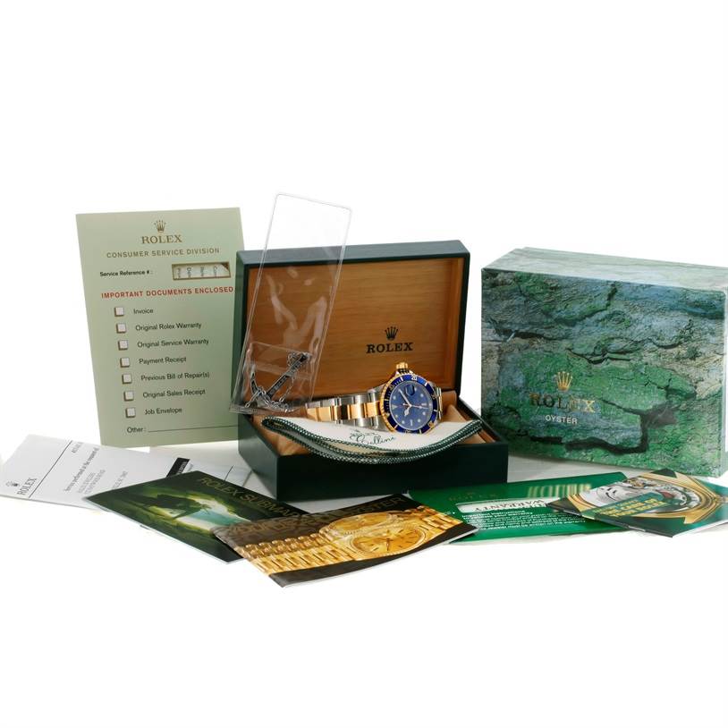 The image shows a Rolex Submariner 16613 Men's Steel and Gold (two tone) Blue Dial 16613 Men's Steel and Gold (two tone) Blue Dial watch in its box, along with related documents and packaging.