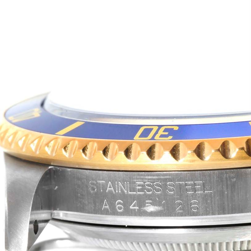 The image shows a side angle of a Rolex Submariner 16613 Men's Steel and Gold (two tone) Blue Dial 16613 Men's Steel and Gold (two tone) Blue Dial watch, detailing the blue and gold bezel and stainless steel casing.