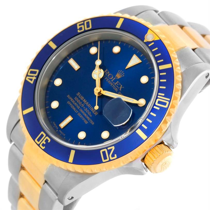 The image shows a close-up angle of a Rolex Submariner 16613 Men's Steel and Gold (two tone) Blue Dial 16613 Men's Steel and Gold (two tone) Blue Dial watch, highlighting the blue dial, gold bezel, and part of the two-tone bracelet.