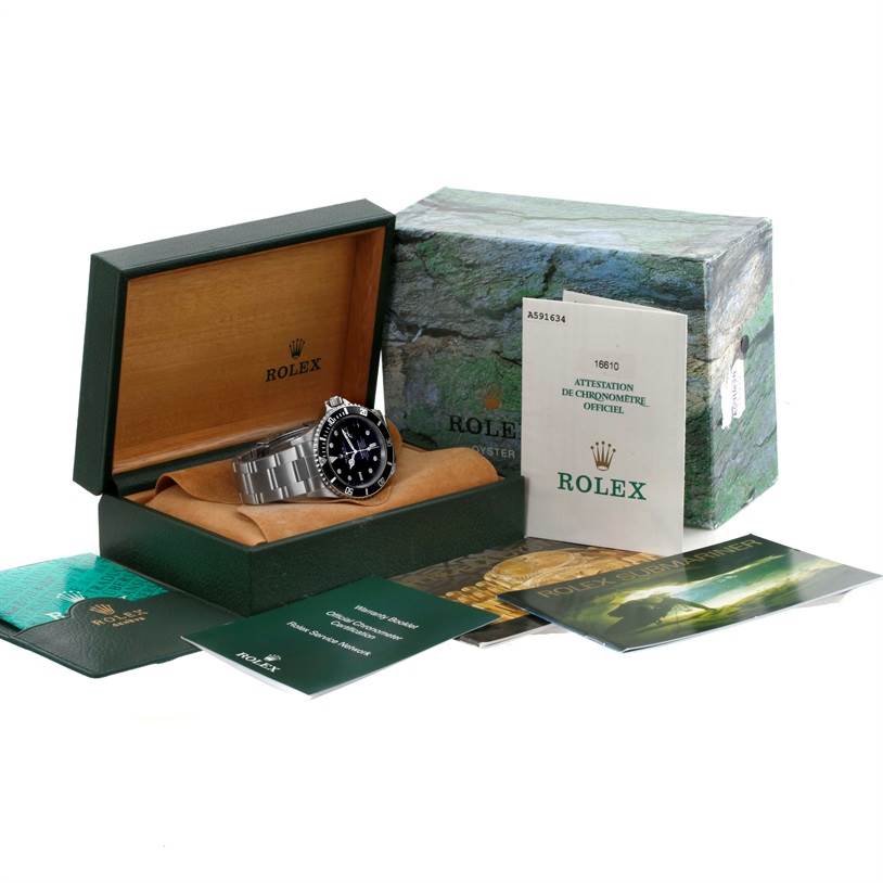 The image shows a Rolex Submariner 16610 Men
s Stainless Steel Black Dial 16610 Men
s Stainless Steel Black Dial watch angled slightly from the front, along with its box, warranty card, booklet, and official papers.
