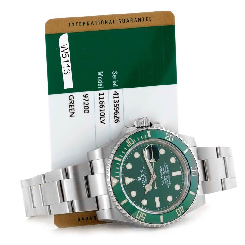 The image shows a Rolex Submariner 116610LV Men's Stainless Steel Green Dial 116610LV Men's Stainless Steel Green Dial watch with a green bezel and dial, along with its international guarantee card.