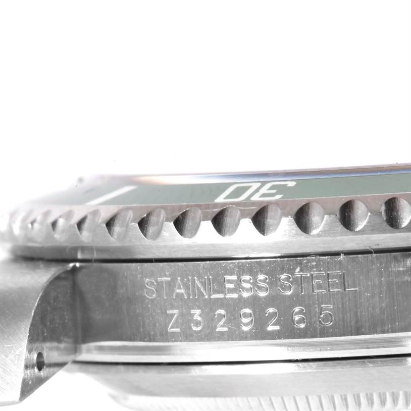 This close-up image shows the side profile of a Rolex Submariner 16610LV Men
s Stainless Steel Black Dial 16610LV Men
s Stainless Steel Black Dial
s bezel and case with the serial number and "STAINLESS STEEL" engraving visible.