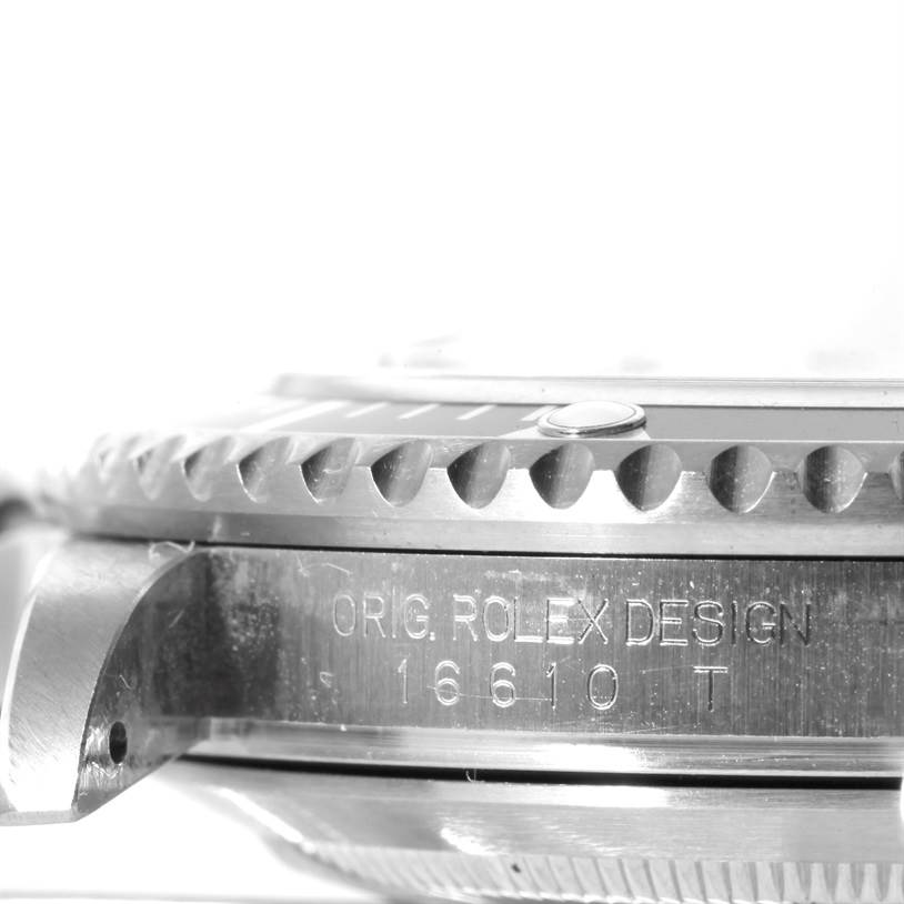 The image shows a close-up side view of the case and bezel of a Rolex Submariner 16610 Men
s Stainless Steel Black Dial 16610 Men
s Stainless Steel Black Dial, with "ORIG. ROLEX DESIGN 16610 T" engraved on it.