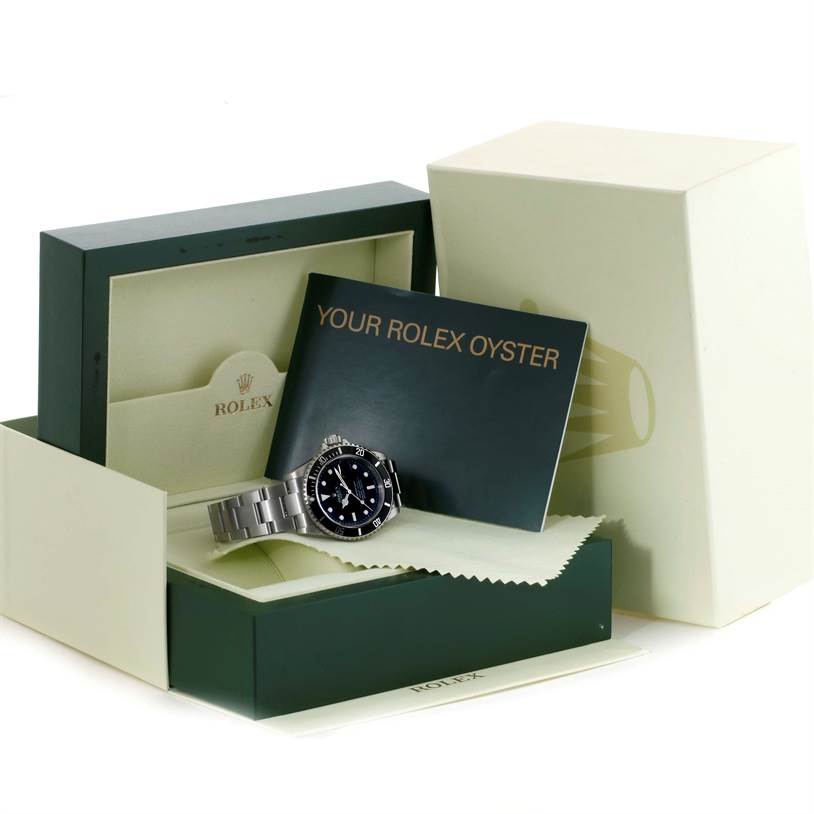 The image shows a Rolex Submariner 16610 Men
s Stainless Steel Black Dial 16610 Men
s Stainless Steel Black Dial watch at an angle with accessories including a box, booklet, and cleaning cloth.