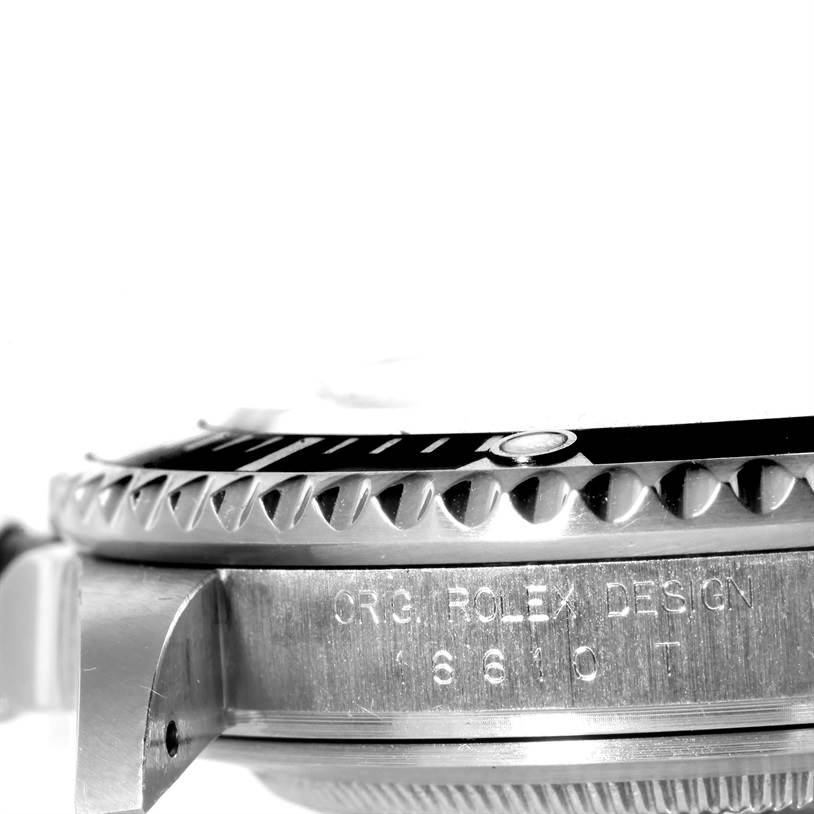 The image shows a side angle close-up of the bezel and case of a Rolex Submariner 16610 Men
s Stainless Steel Black Dial 16610 Men
s Stainless Steel Black Dial watch, highlighting its serrated edge and engraved details.