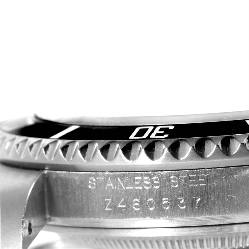 The image shows a side view of a Rolex Submariner 16610 Men
s Stainless Steel Black Dial 16610 Men
s Stainless Steel Black Dial, focusing on the stainless steel bezel and engraved serial number.