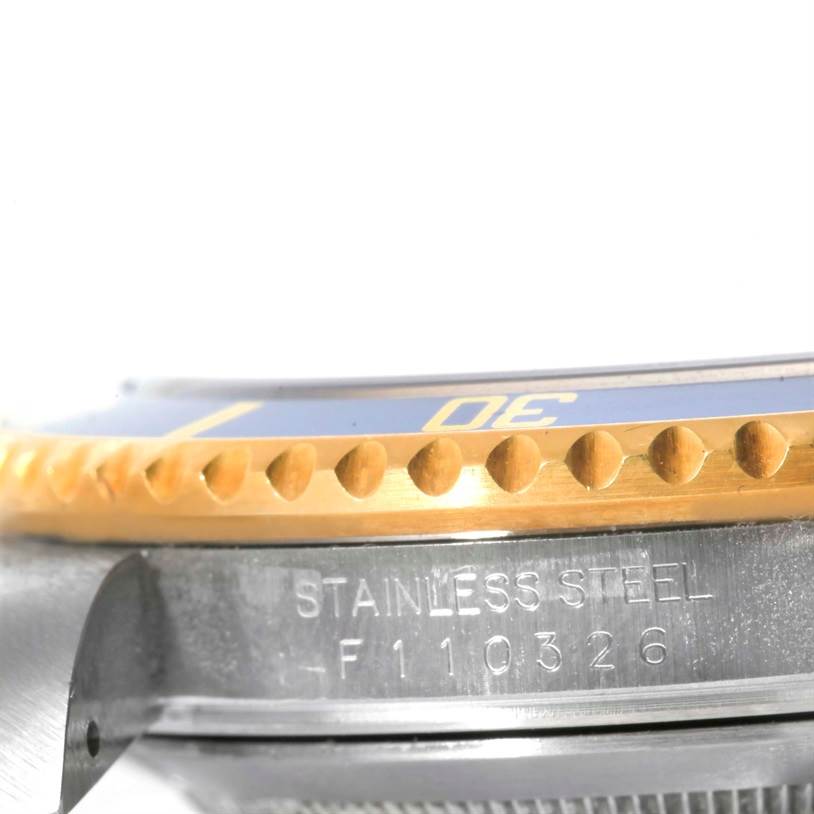 The image shows a close-up of the bezel and part of the stainless steel case of a Rolex Submariner 16613 Men's Steel and Gold (two tone) Blue Dial 16613 Men's Steel and Gold (two tone) Blue Dial watch.
