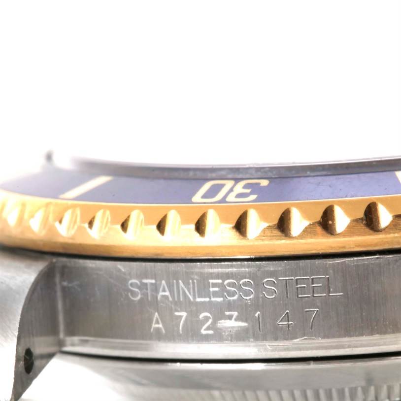 The image shows a close-up of the Rolex Submariner 16613 Men
s Steel and Gold (two tone) Blue Dial 16613 Men
s Steel and Gold (two tone) Blue Dial watch, highlighting the stainless steel case and the gold and blue bezel with the number "30."