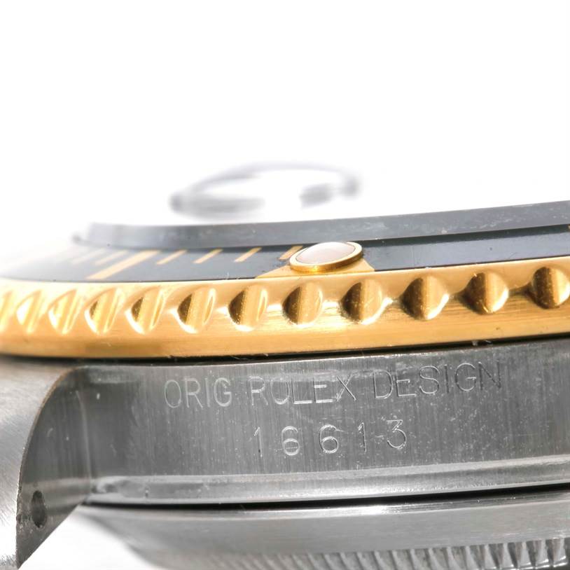 This close-up image shows the side view of the bezel, crown, and case of a Rolex Submariner 16613 Men's Steel and Gold (two tone) Black Dial 16613 Men's Steel and Gold (two tone) Black Dial model.