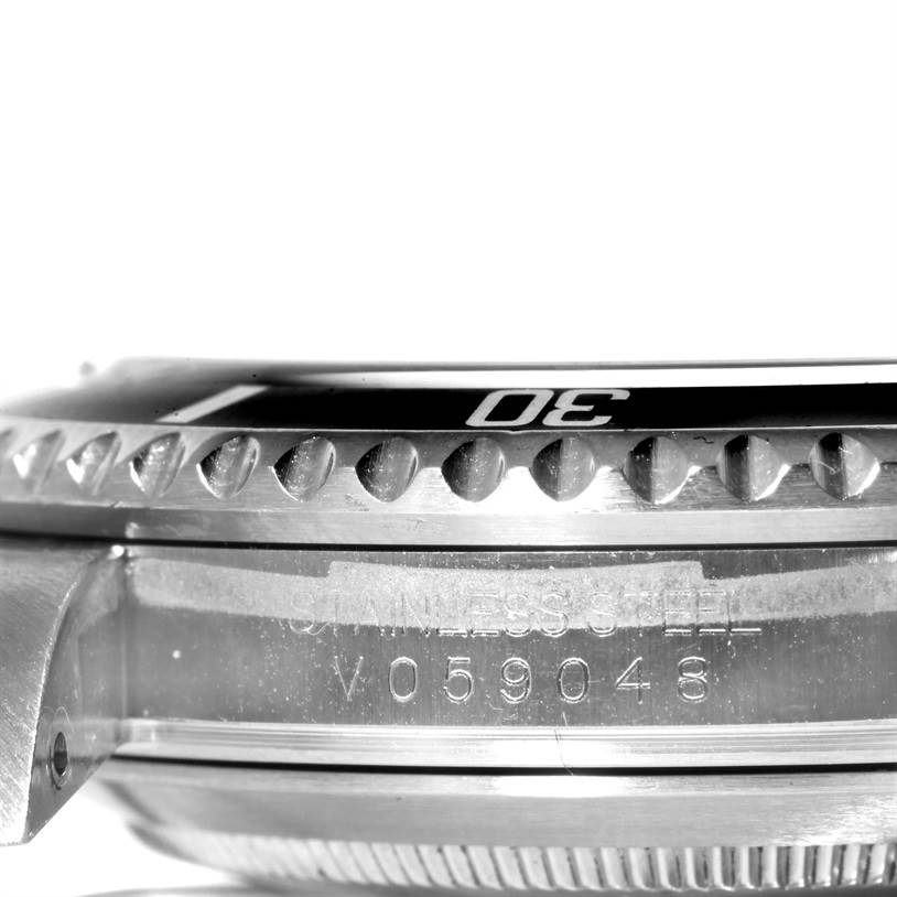 The image shows a side view of a Rolex Submariner 16610 Men
s Stainless Steel Black Dial 16610 Men
s Stainless Steel Black Dial
s stainless steel case, revealing the bezel and part of the serial number.