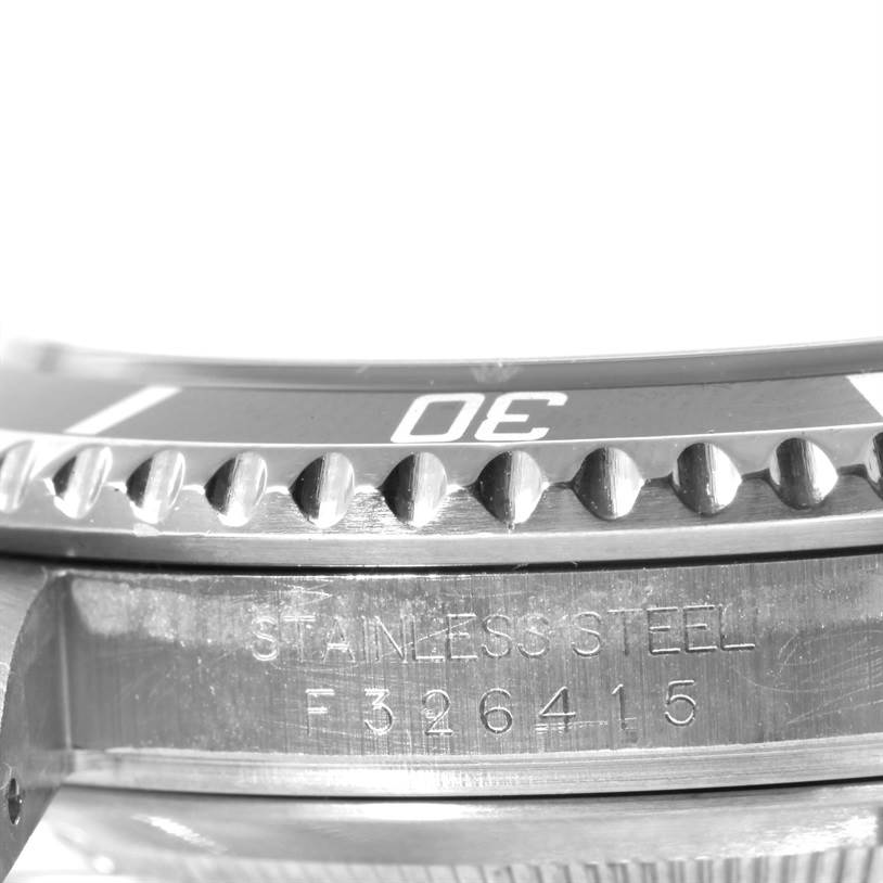 The image shows a close-up of the bezel and case side of a Rolex Submariner 16610 Men
s Stainless Steel Black Dial 16610 Men
s Stainless Steel Black Dial watch, highlighting the stainless steel and serial number.