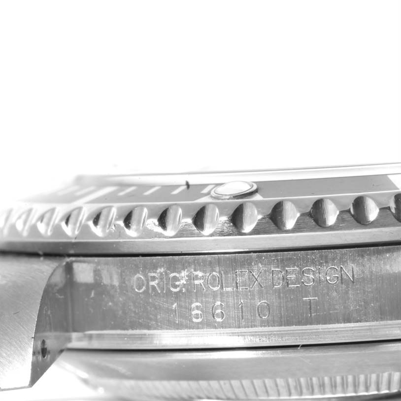 The image shows a close-up side view of a Rolex Submariner 16610 Men
s Stainless Steel Black Dial 16610 Men
s Stainless Steel Black Dial watch, highlighting the engraved case and part of the bezel.