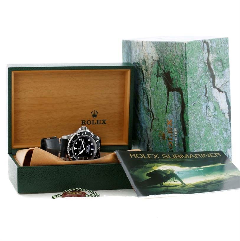 The image shows a Rolex Submariner 16610 Men
s Stainless Steel Black Dial 16610 Men
s Stainless Steel Black Dial watch in its box with its booklet and outer packaging visible from a front angle.