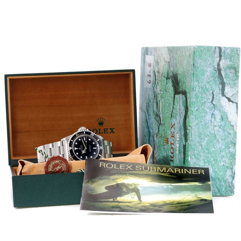 The image shows a Rolex Submariner 14060 Men
s Stainless Steel Black Dial 14060 Men
s Stainless Steel Black Dial watch with a box, booklet, and warranty seal included.