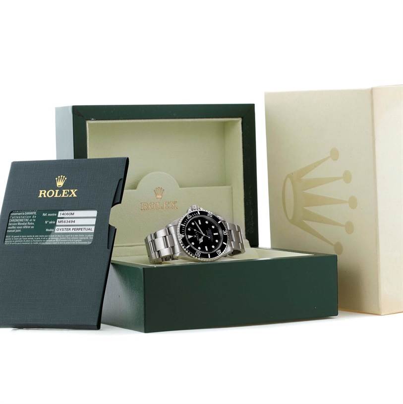 The image shows a Rolex Submariner 14060 Men
s Stainless Steel Black Dial 14060 Men
s Stainless Steel Black Dial watch displayed at an angle inside its open box with accompanying documentation and outer packaging.
