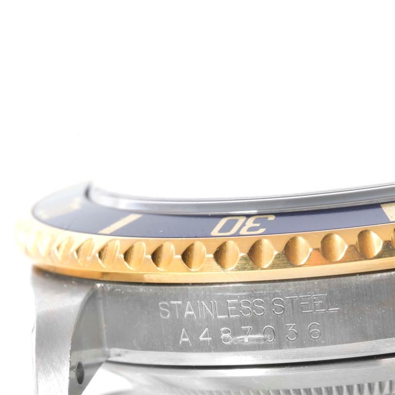 This image shows a close-up of the side of a Rolex Submariner 16613 Men
s Steel and Gold (two tone) Blue Dial 16613 Men
s Steel and Gold (two tone) Blue Dial watch, featuring the bezel and part of the stainless steel casing.