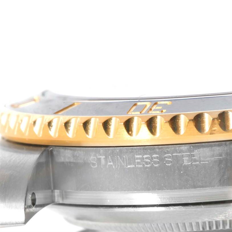 This close-up image of the Rolex Submariner 116613 Men
s Steel and Gold (two tone) Black Dial 116613 Men
s Steel and Gold (two tone) Black Dial watch highlights the side profile of the bezel and part of the stainless steel case.