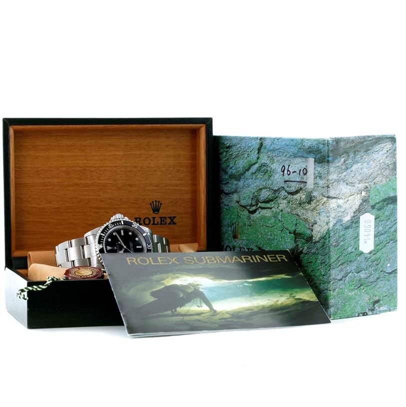 The image shows a Rolex Submariner 14060 Men
s Stainless Steel Black Dial 14060 Men
s Stainless Steel Black Dial watch with its original box and manual, photographed from a front angle.