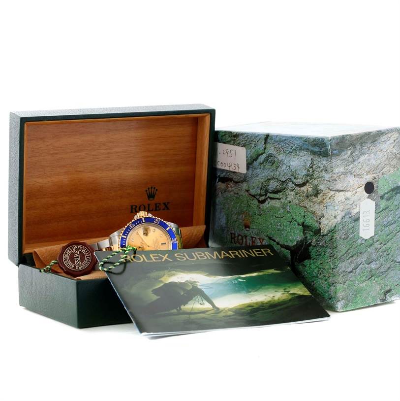 The image shows a Rolex Submariner 16613 Men's Steel and Gold (two tone) Champagne Dial 16613 Men's Steel and Gold (two tone) Champagne Dial watch in its open wooden box, with the outer box and a Rolex Submariner 16613 Men's Steel and Gold (two tone) Champagne Dial 16613 Men's Steel and Gold (two tone) Champagne Dial booklet nearby.