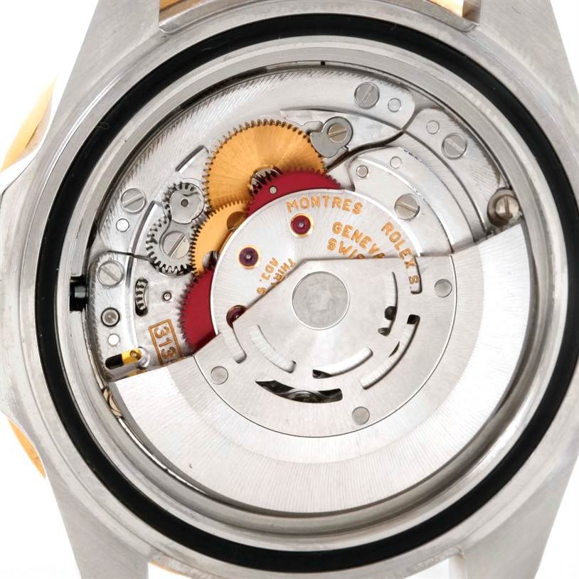 The image shows the internal mechanics and movement of a Rolex Submariner 16613 Men
s Steel and Gold (two tone) Black Dial 16613 Men
s Steel and Gold (two tone) Black Dial watch from a rear angle.