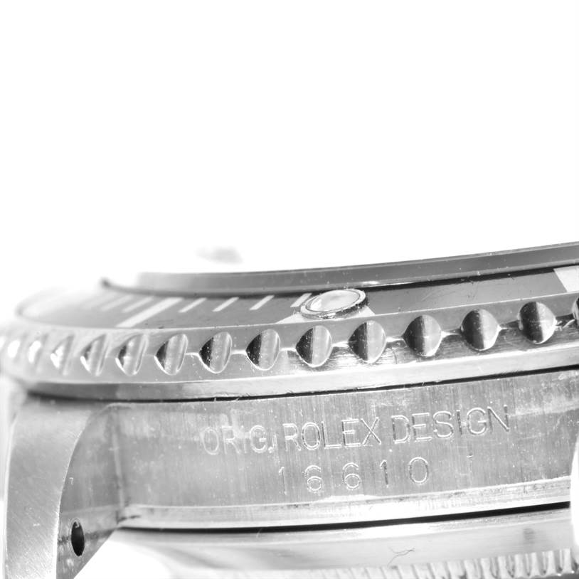 The image shows a side angle of a Rolex Submariner 16610 Men
s Stainless Steel Black Dial 16610 Men
s Stainless Steel Black Dial, highlighting the bezel, case, and engraved design information.