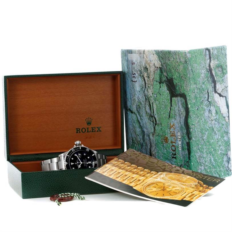 The image shows a Rolex Submariner 16610 Men
s Stainless Steel Black Dial 16610 Men
s Stainless Steel Black Dial watch in its box with manuals and additional accessories.