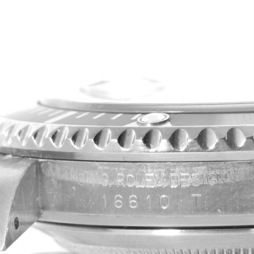 This close-up of the Rolex Submariner 16610 Men
s Stainless Steel Black Dial 16610 Men
s Stainless Steel Black Dial shows the side view of the bezel and engraved case with the model number 16610 T.