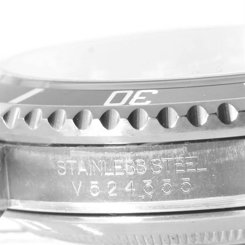 This image shows a close-up of the side of a Rolex Submariner 16610 Men
s Stainless Steel Black Dial 16610 Men
s Stainless Steel Black Dial watch, detailing part of the bezel and the serial number.