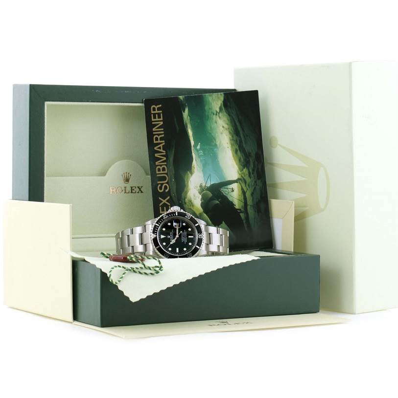 The image shows a Rolex Submariner 16610 Men
s Stainless Steel Black Dial 16610 Men
s Stainless Steel Black Dial watch in its open box with accompanying manuals and tags.